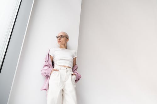 Fashionable woman in light room near wall