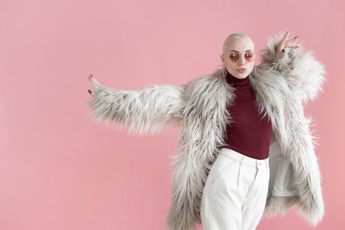 Free Fashionable woman in fur coat dancing in studio Stock Photo