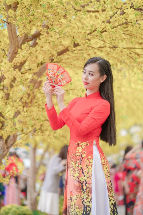 Woman in a Red Dress Holding Red Envelopes