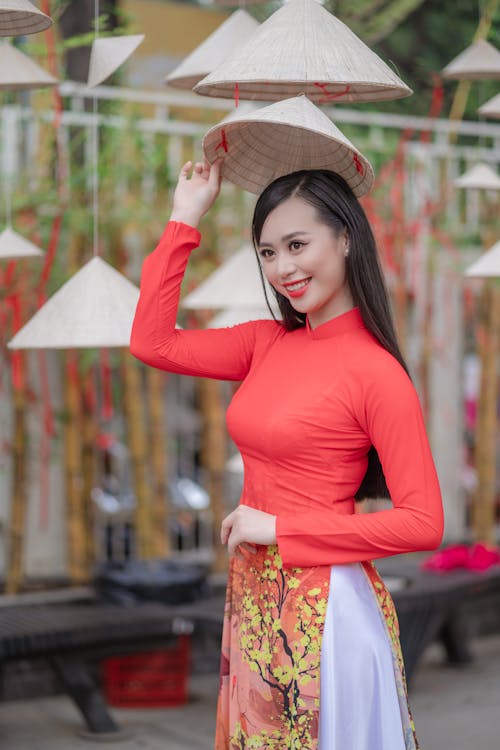 Selective Focus Photo of a Woman Touching an Asian Conical Hat