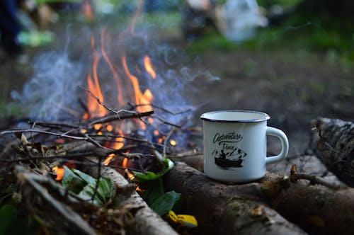 White Ceramic Mug on Top of Woods