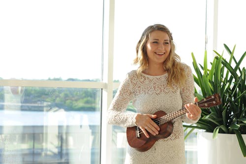 Mulher Usando Vestido Floral Branco Jogando Ukulele