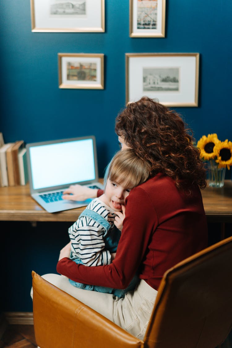 A Boy Sitting To His Mother