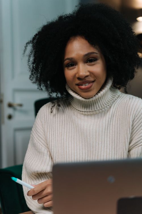 Free A woman smiles confidently in her home office, enhancing remote work productivity. Stock Photo
