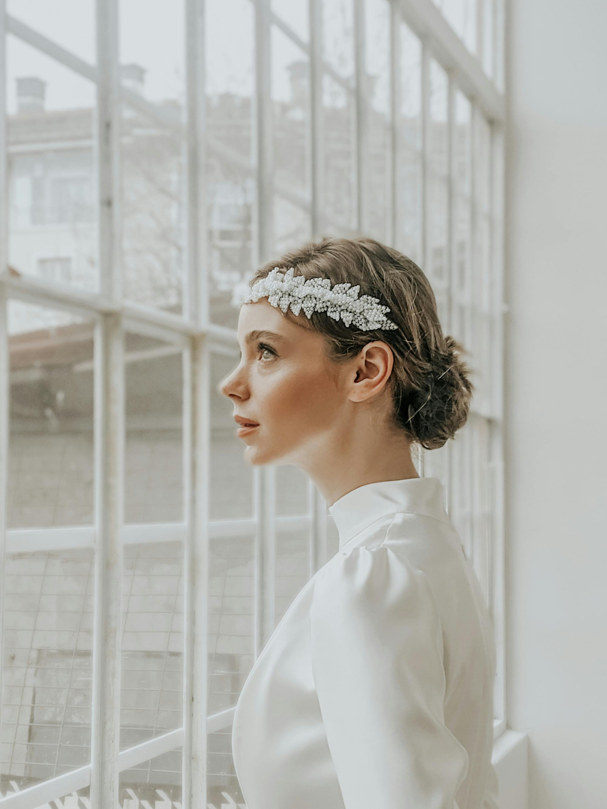 dreamy elegant woman in hairband near windows