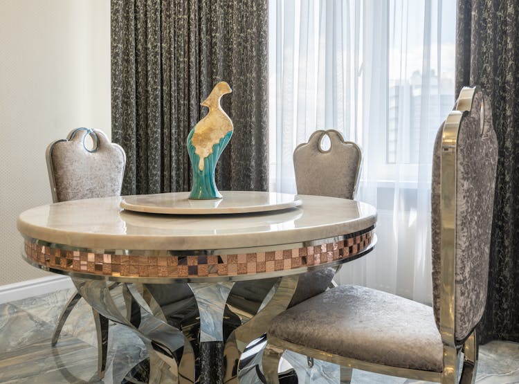 Dining Room Interior With Bird Statuette On Table In Apartment