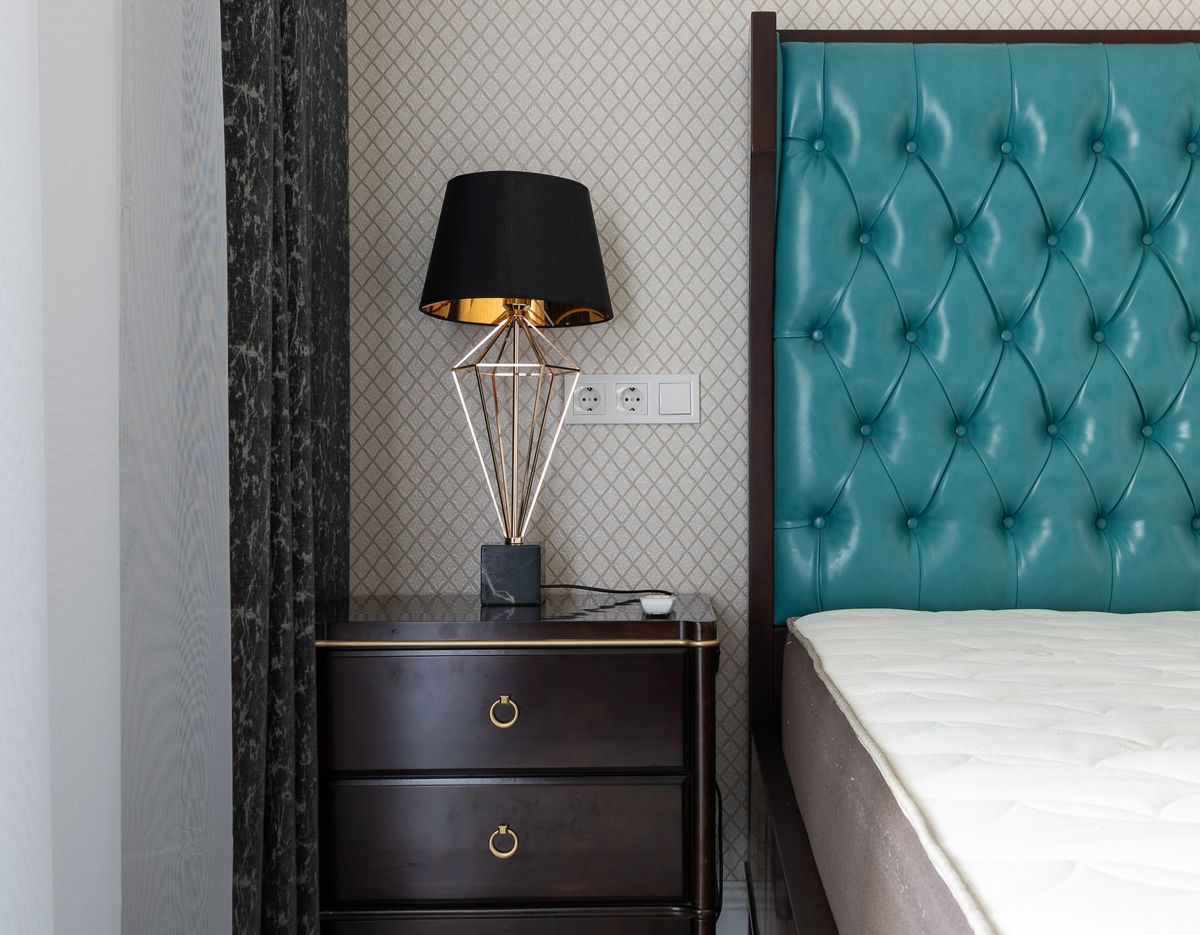 Contemporary bedroom with bedside table, statement lamp and layered soft furnishings