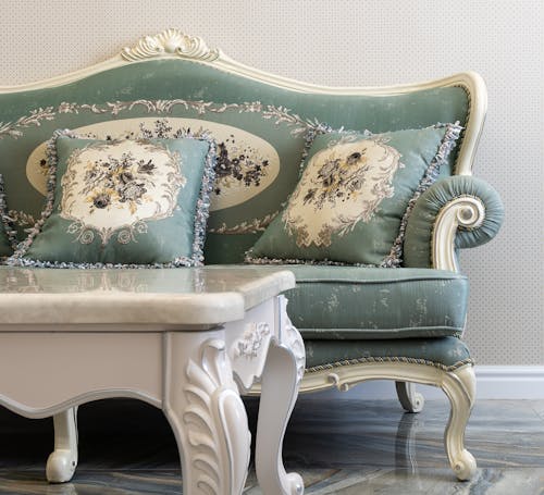 Living room interior with white table against cushions with floral ornament on couch in light house