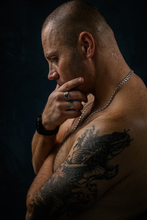 Side View of a Topless Man with an Arm Tattoo