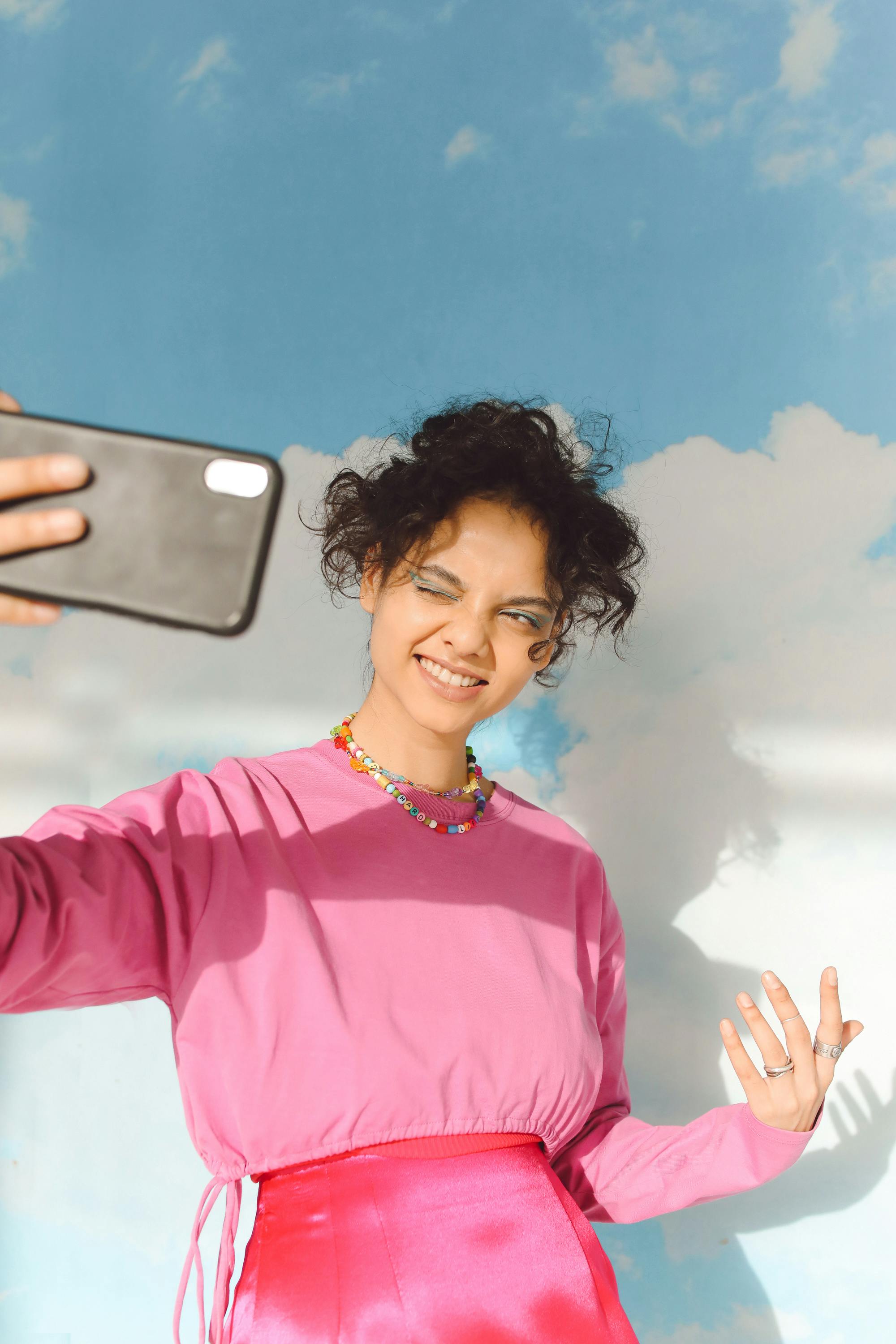 a girl in pink sweater taking selfie