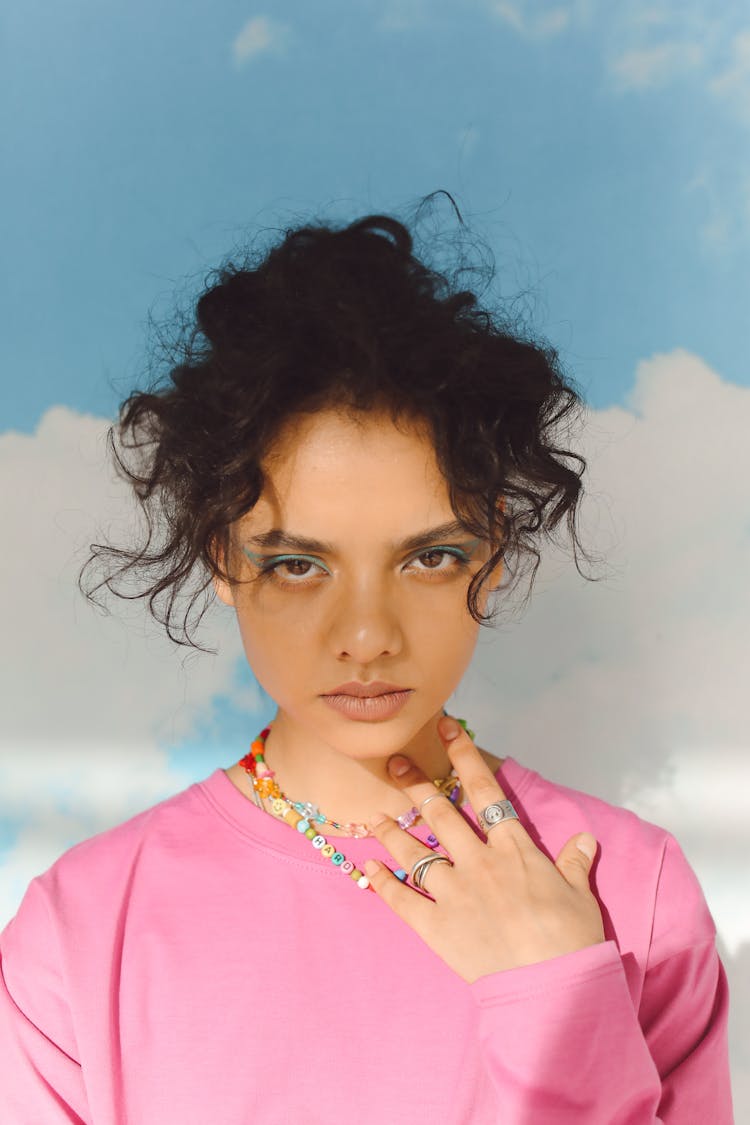 Portrait Of A Young Woman In A Pink Sweatshirt And Colorful Necklace 