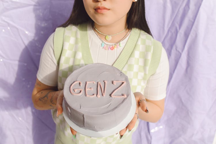 Woman In Green Vest Holding A Cake