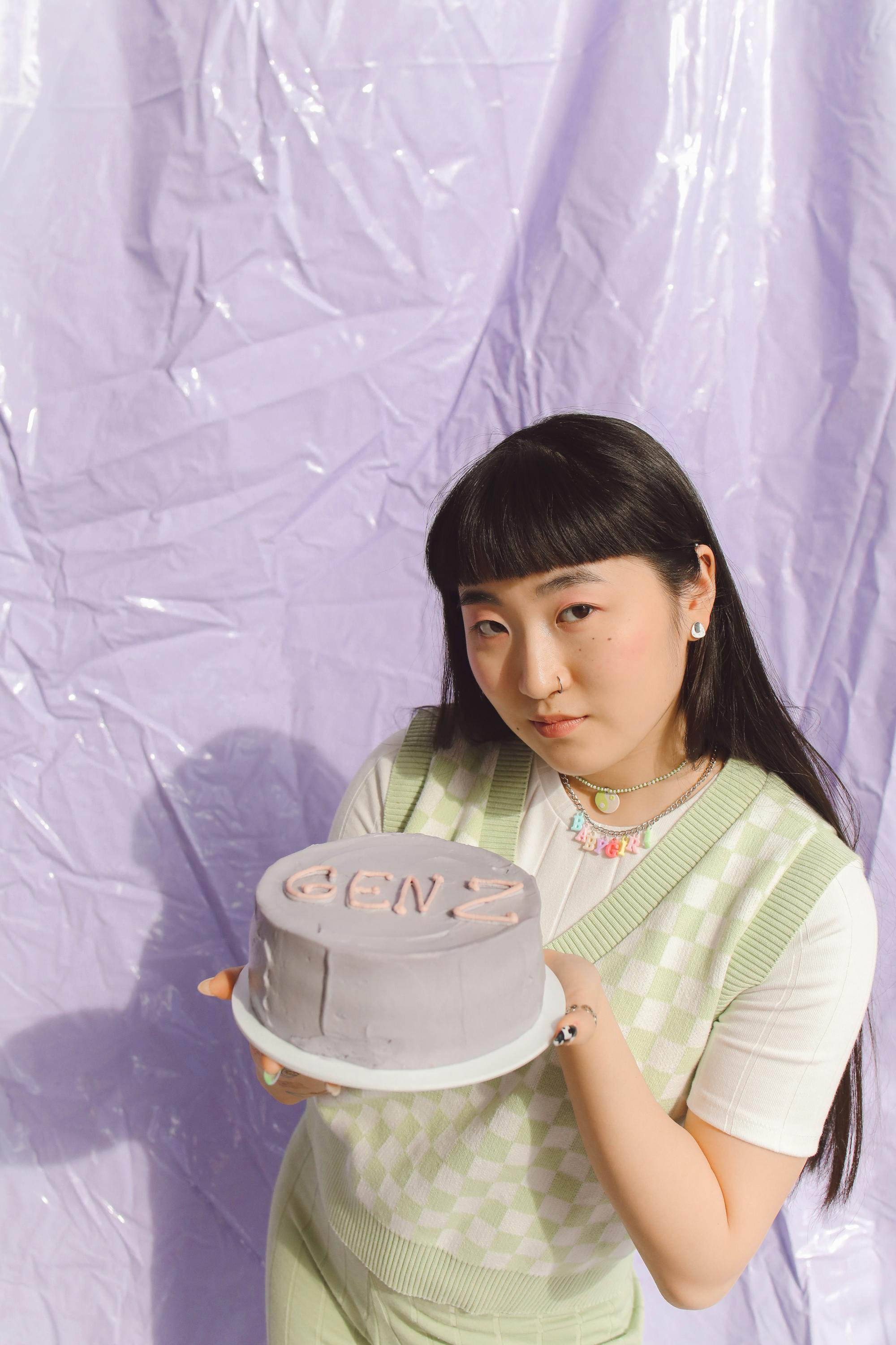 Woman Holding a Cake while Seriously Looking at the Camera · Free Stock