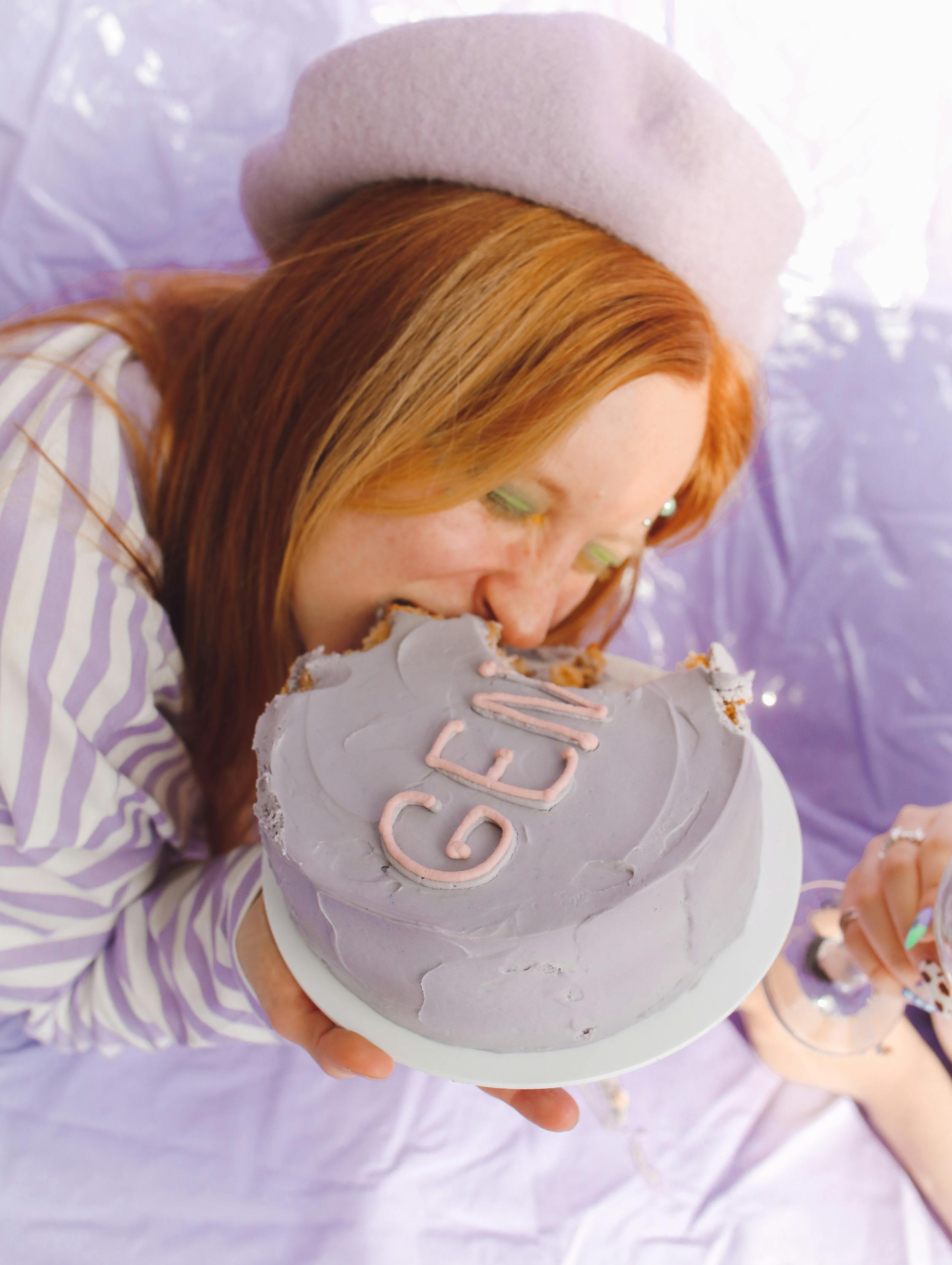 woman taking a bite of the cake she is holding