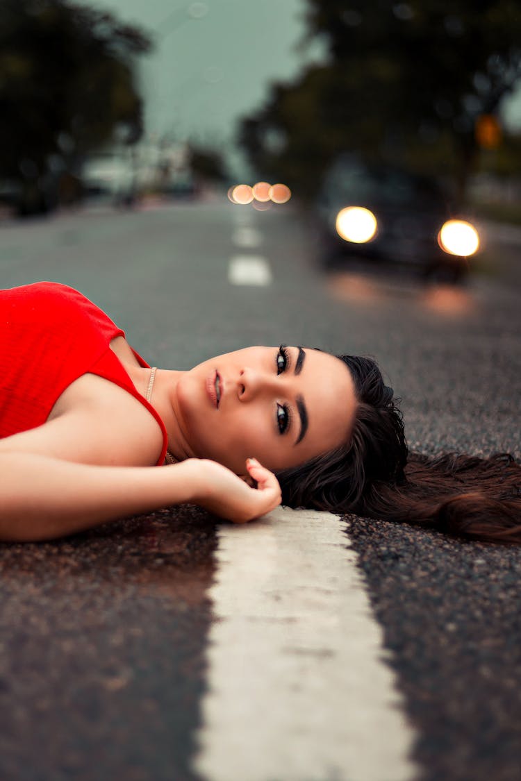 Woman In Red Tank Top Lying On The Road