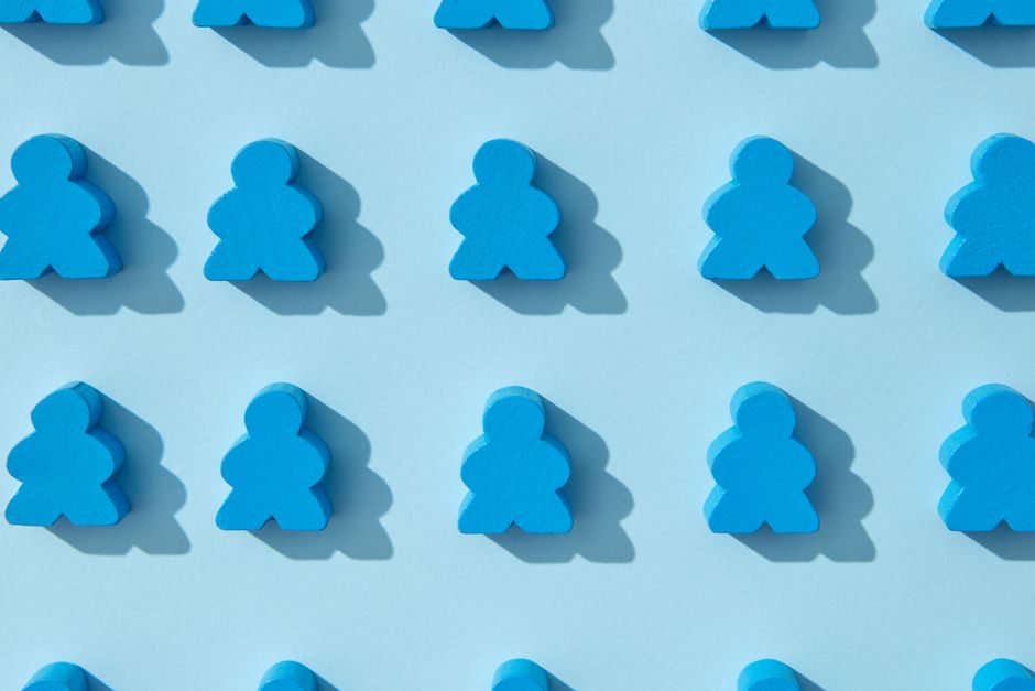 Flat lay of blue wooden meeples on a light blue background, showcasing repetition and minimalism. Flat lay of blue wooden meeples on a light blue background, showcasing repetition and minimalism.
