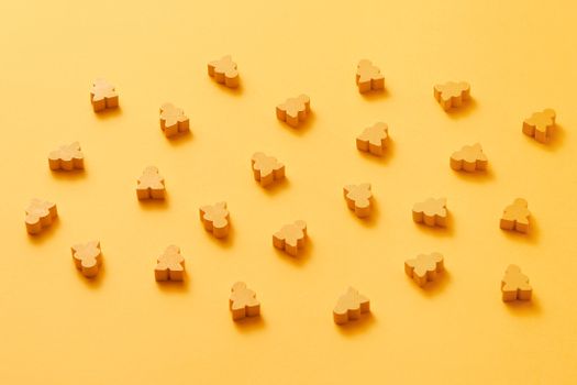 A minimalist arrangement of yellow meeple figures on a vibrant monochrome yellow background.