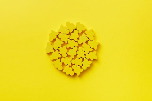 Vibrant yellow figurines arranged in a circle on a matching yellow background, creating a bold, minimalist design.