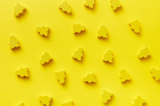 Bright yellow abstract pattern with toy meeples against a yellow background, ideal for design concepts.