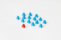 Photo of Blue Meeples Near a Red Meeple Piece