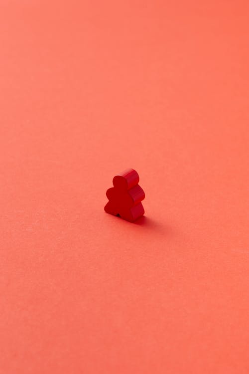 Photo of a Meeple Piece on a Red Surface