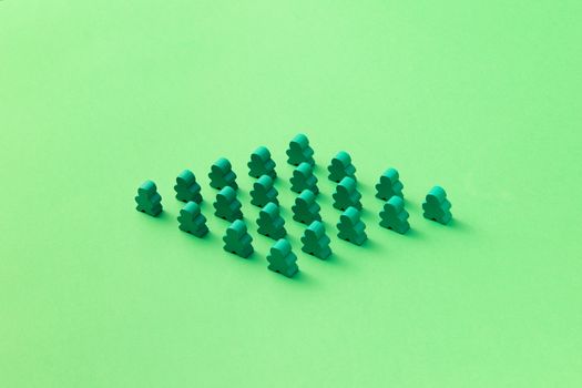 Green meeples arranged in a triangular pattern on a vivid green background. Perfect for board game themes.