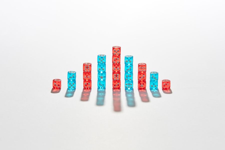 Vibrant red and blue dice stacked creatively in a graph-like formation casting shadows.