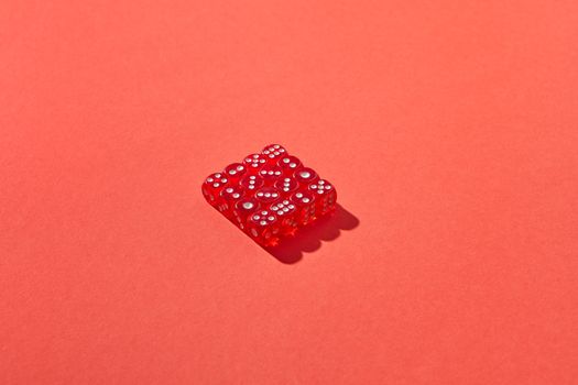 A set of red dice in shadow on a bold red background, creating a striking geometric design.