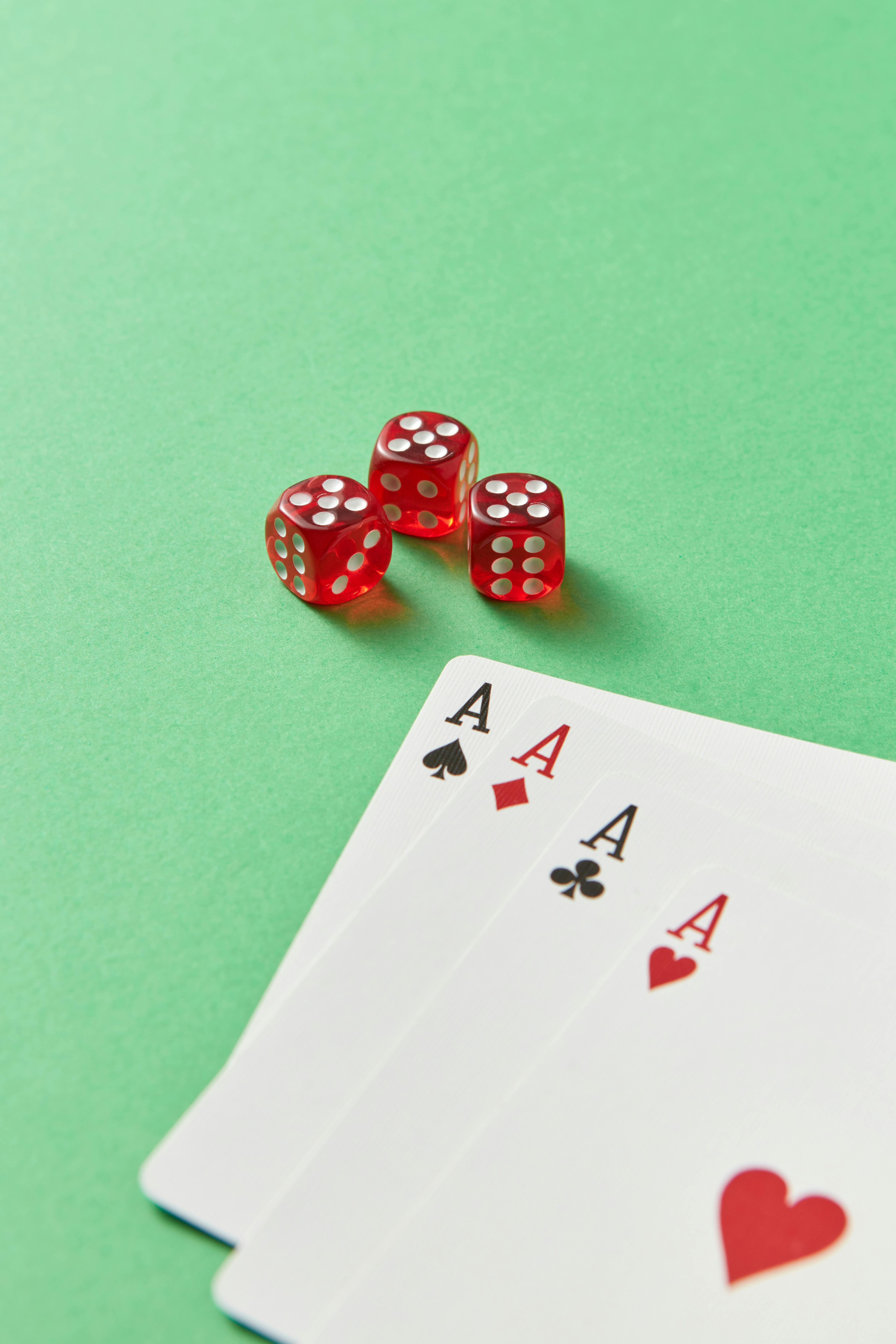 red dice beside poker cards