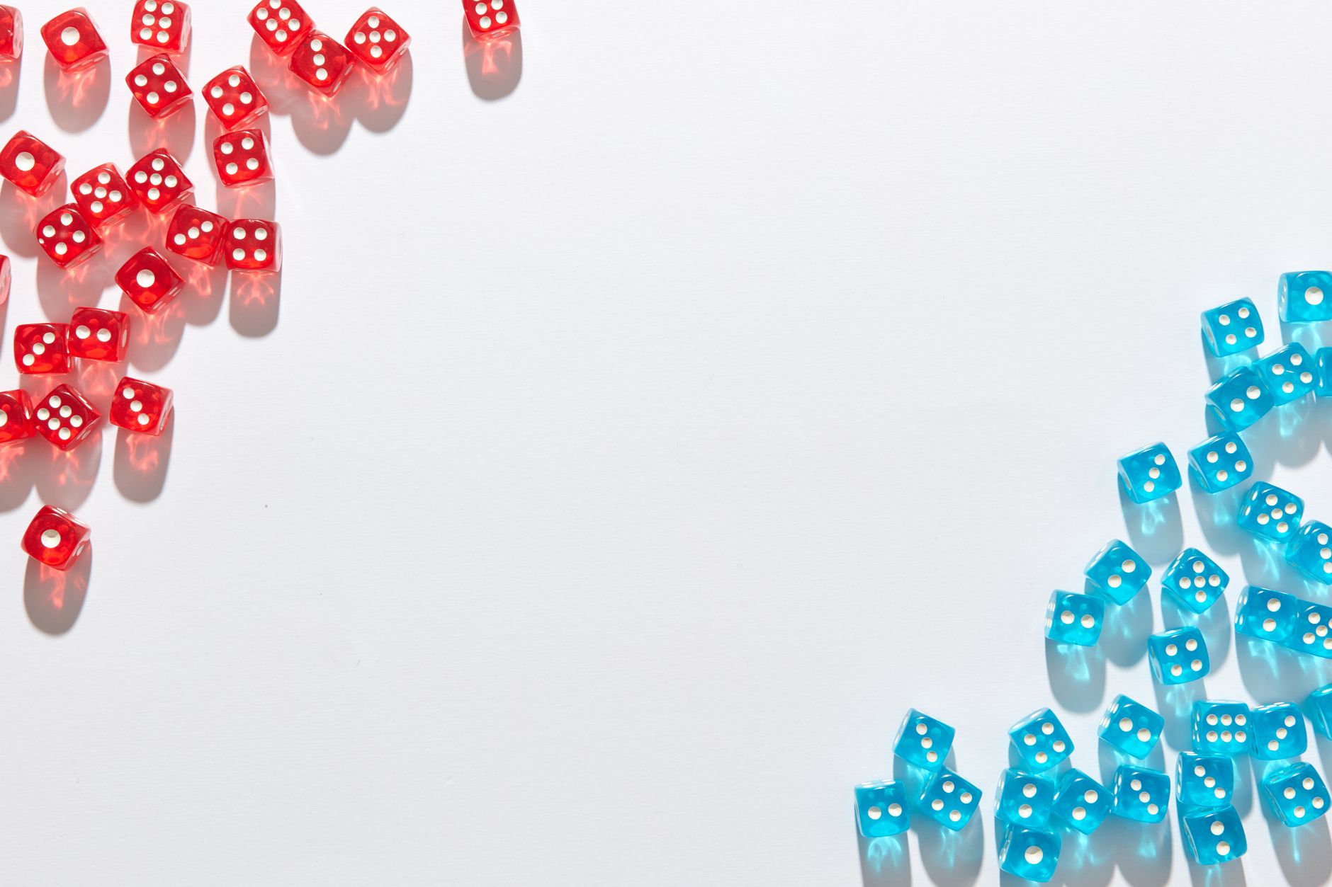 A flat lay of red and blue transparent dice on a white background, perfect for game night themes.
