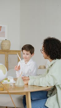 A young boy learns about wind energy with a teacher in an indoor setting.
