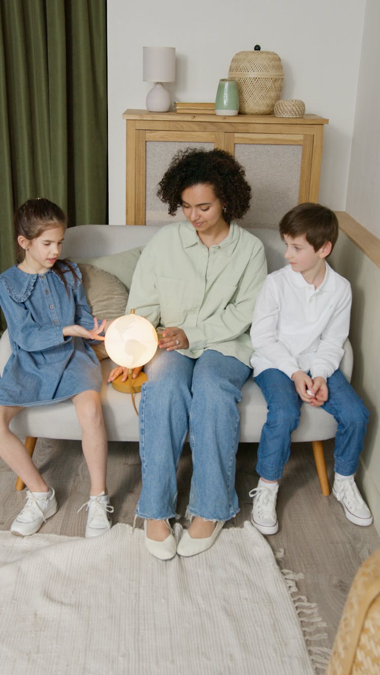 Woman And Kid Playing A Globe