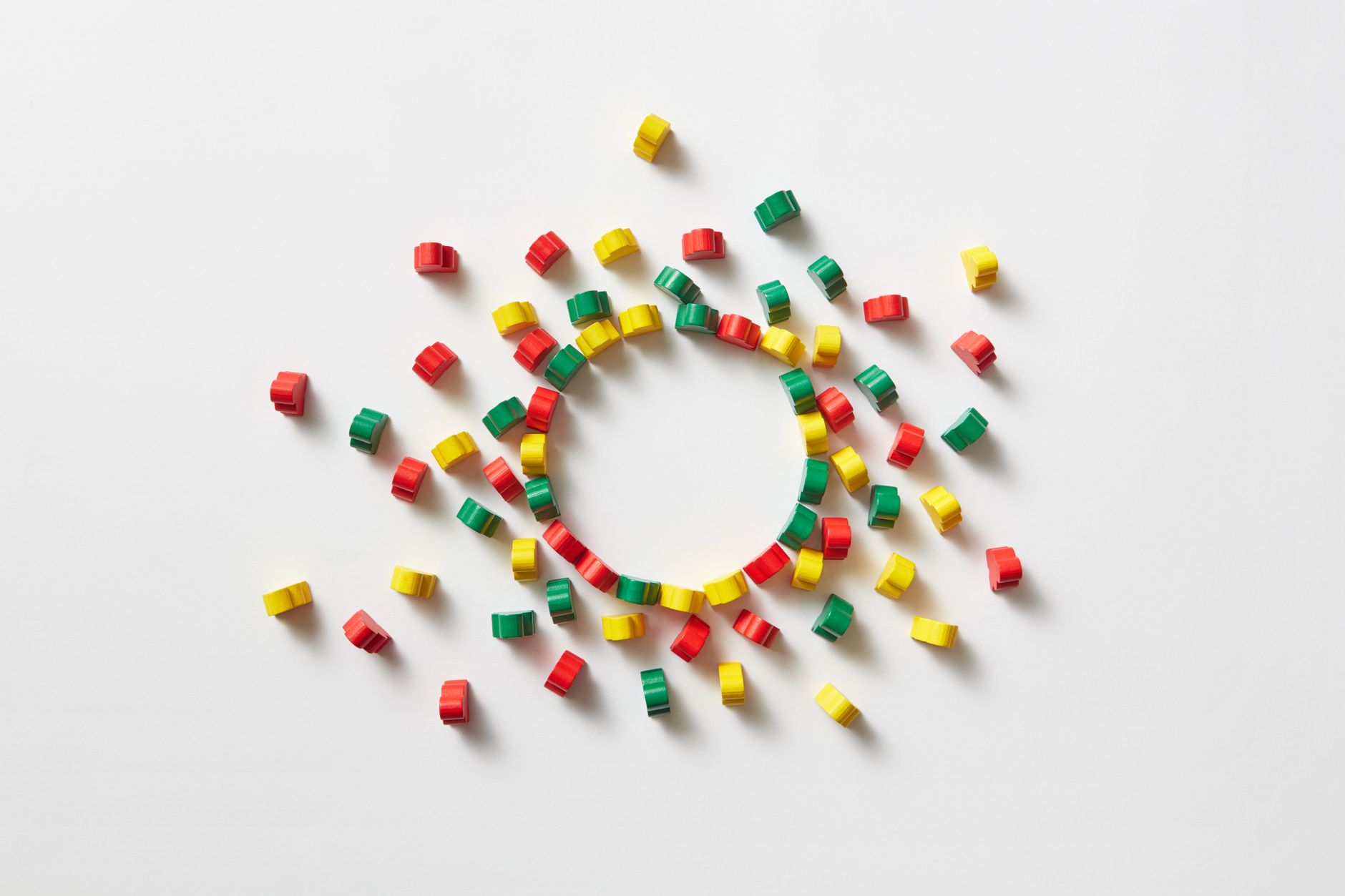 A creative flat lay of colorful wooden blocks forming a circle on a white background.