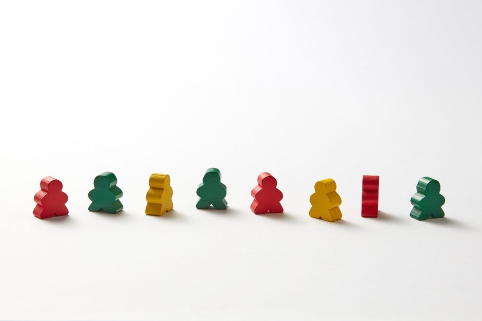 An arrangement of colorful wooden game pieces against a white background, ideal for play concepts.