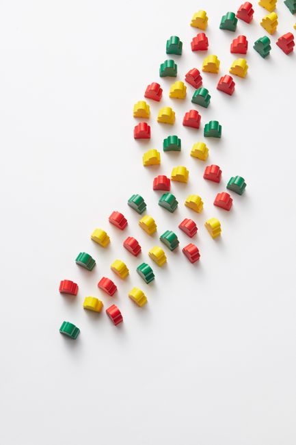 Vibrant red, yellow, and green toy blocks arranged on a white background for creative design.