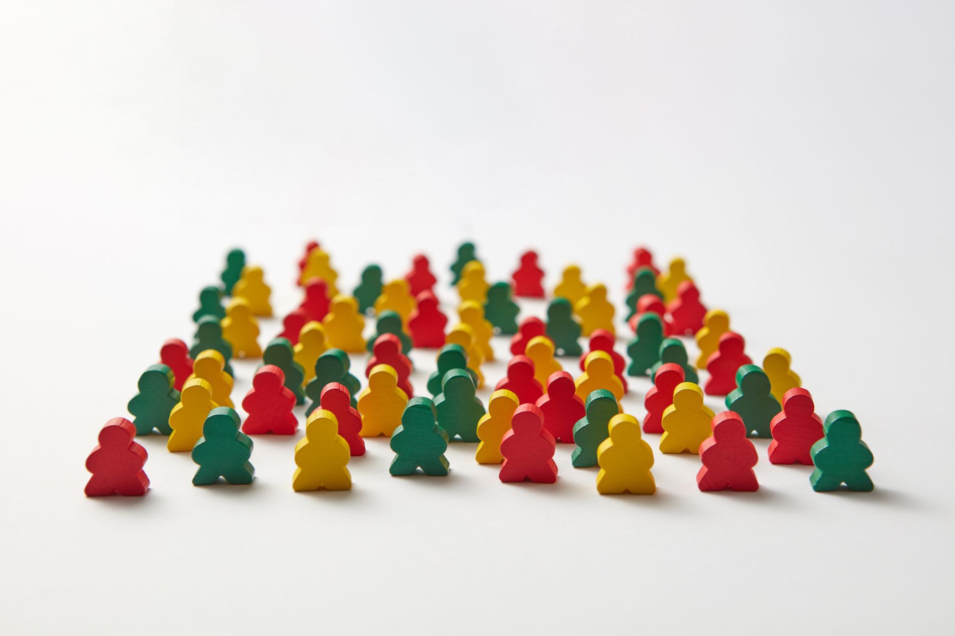 A collection of colorful wooden figures arranged on a white background in a grid-like pattern.