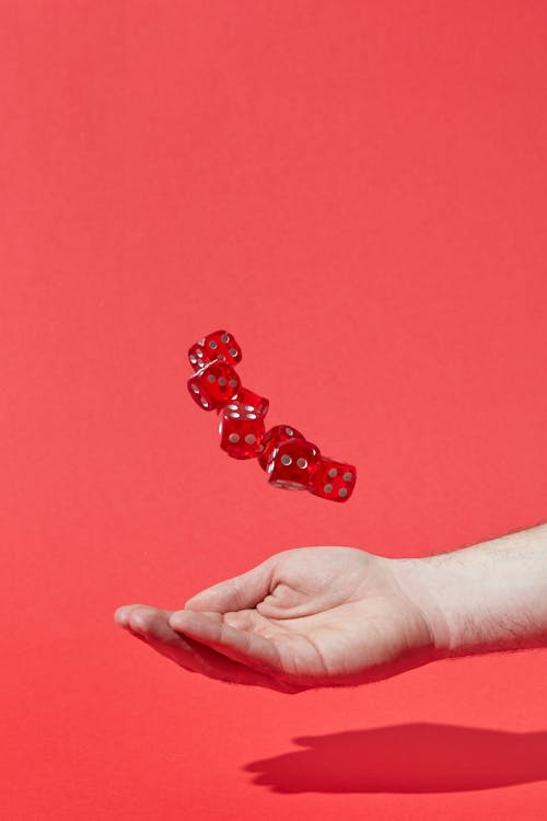 Free Hand Catching Red Translucent Dices Stock Photo