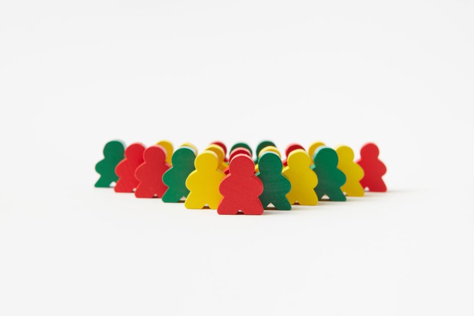 Vibrant wooden toy figures arranged in rows against a plain background, emphasizing organization and creativity.