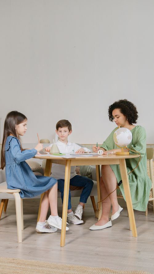 Free A teacher engages young students in classroom activities, promoting learning and interaction. Stock Photo