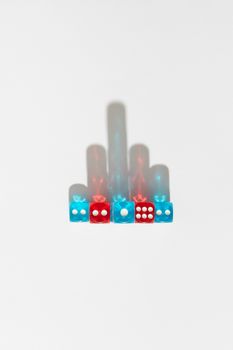 Colorful dice arranged on a white background casting artistic shadows, top view.
