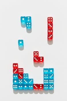 Creative arrangement of red and blue dice mimicking Tetris shapes on white background.