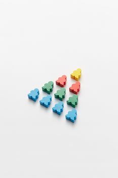 Colorful wooden block figures arranged in a triangle shape on white background.