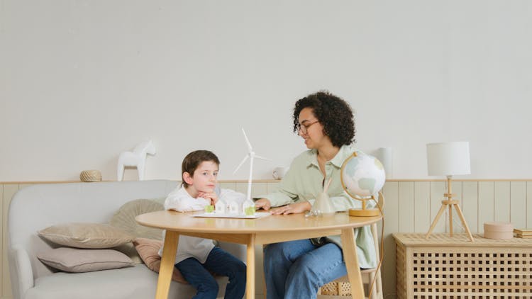 A Woman Tutoring A Boy