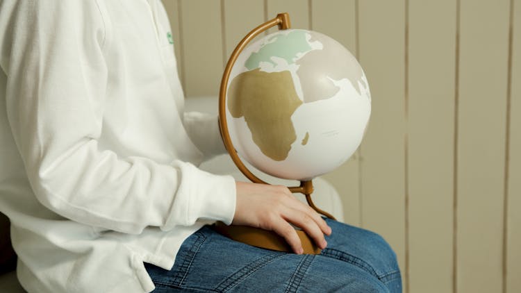 A Close-Up Shot Of A Person Holding A Globe