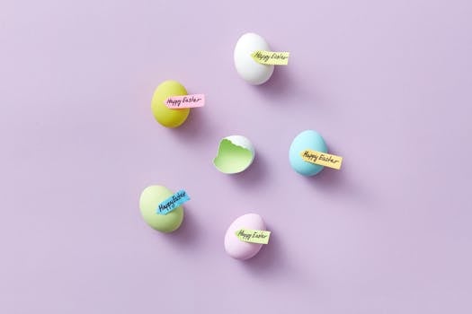 Top view of vibrant Easter eggs with 'Happy Easter' tags on pastel surface.