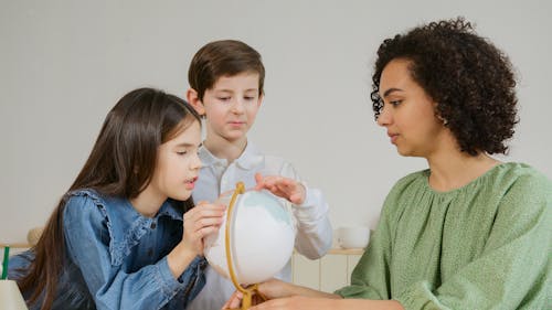 Woman Showing a Globe to the Children