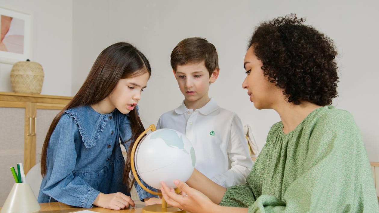 A Woman Showing Kids a Globe