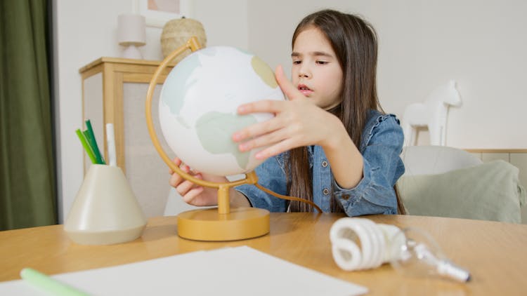 A Girl Holding A Globe