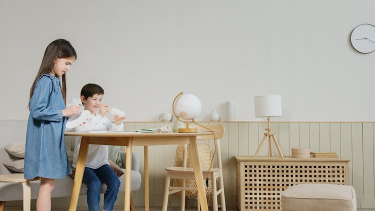 Siblings Holding Disposable Tableware