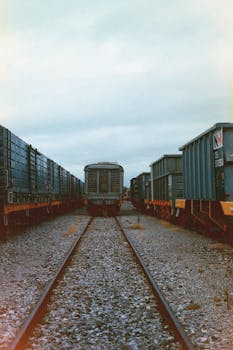 Freight train on gravel railway tracks in a cloudy industrial setting in Rosario, Argentina.